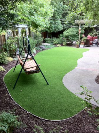 Artificial grass in low traffic backyard with bender board edge