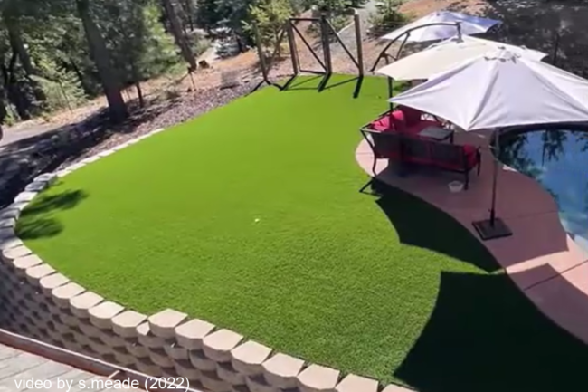 A photo of a stunning transformation from bark and dirt to this lush ever green artificial grass lawn just off the deck of a pool in the Sierra Foothills.